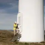 technicien de maintenance éolien devant une éolienne
