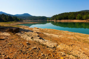Lac bordé de berges rocheuses et de collines boisée